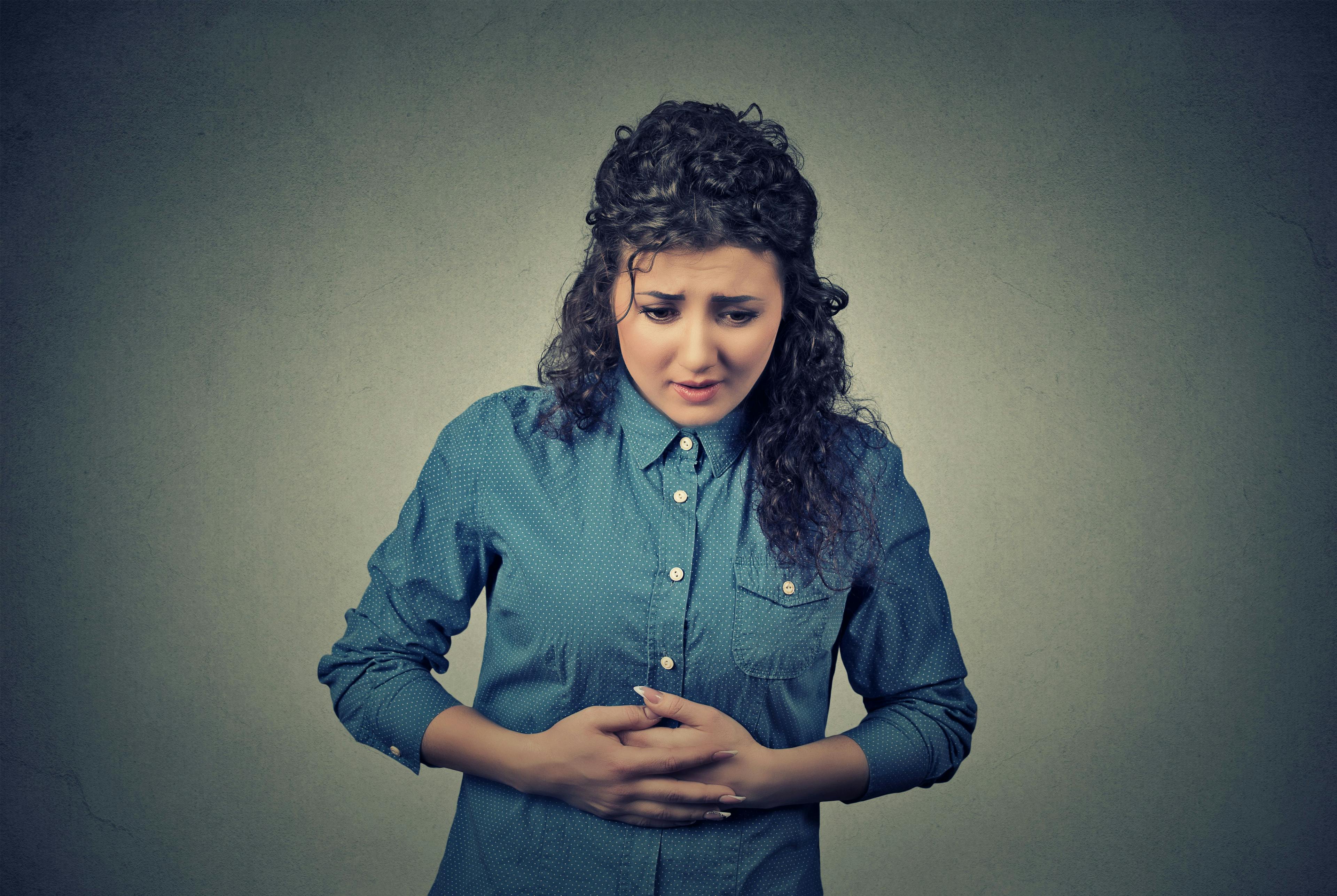 Woman with a stomach ache holding stomach | Credit: Fotolia