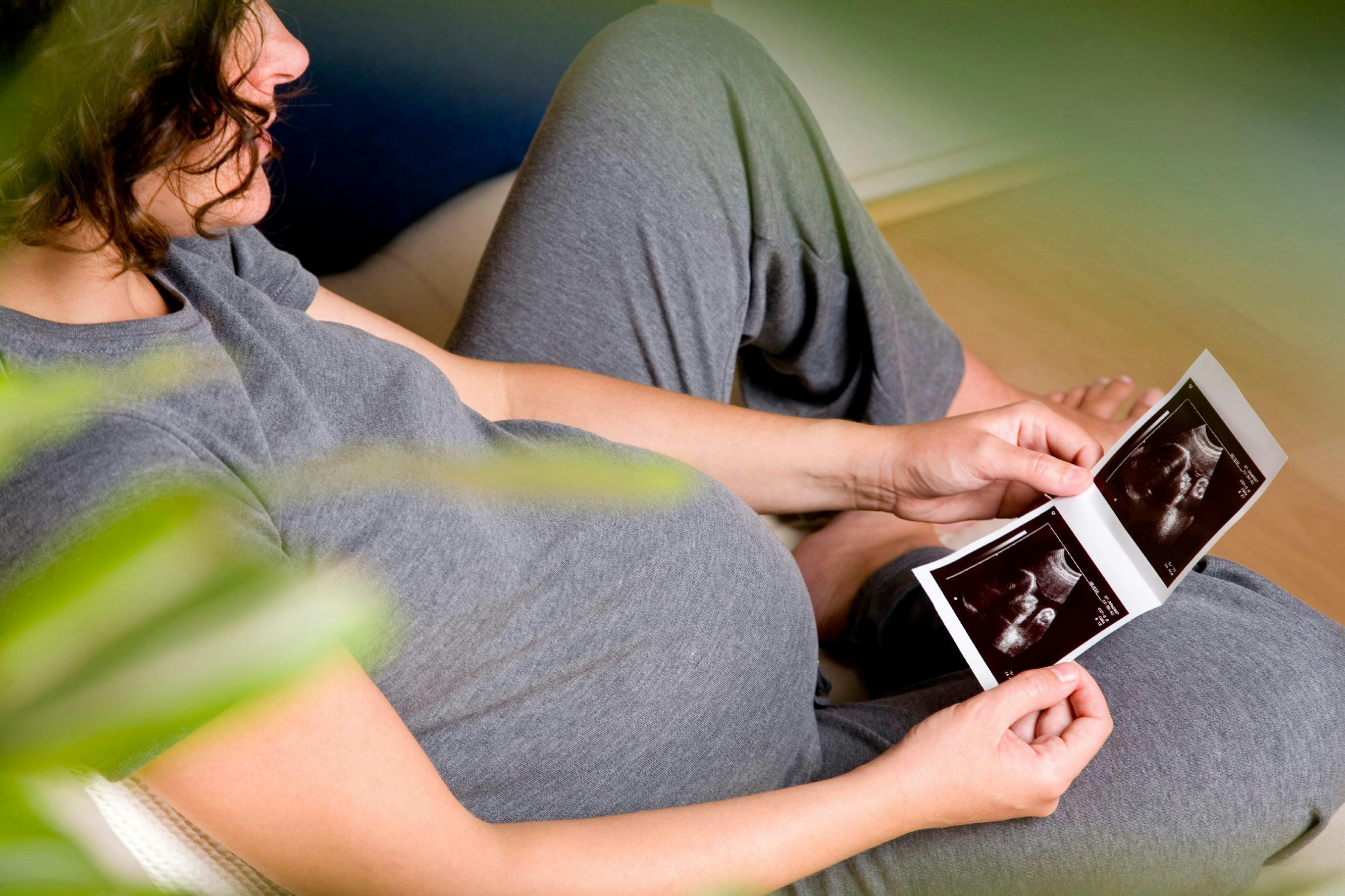 Pregnant woman looking at ultrasound photos