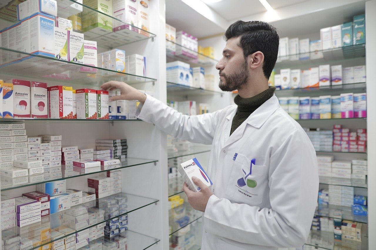 Male pharmacist stocks shelves with pharmaceuticals. | Credit: Pixabay