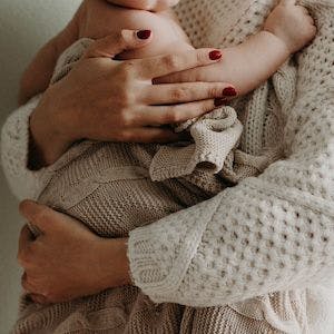 Mother holding child | Image Credit: Pexels/Kristina Paukshtite