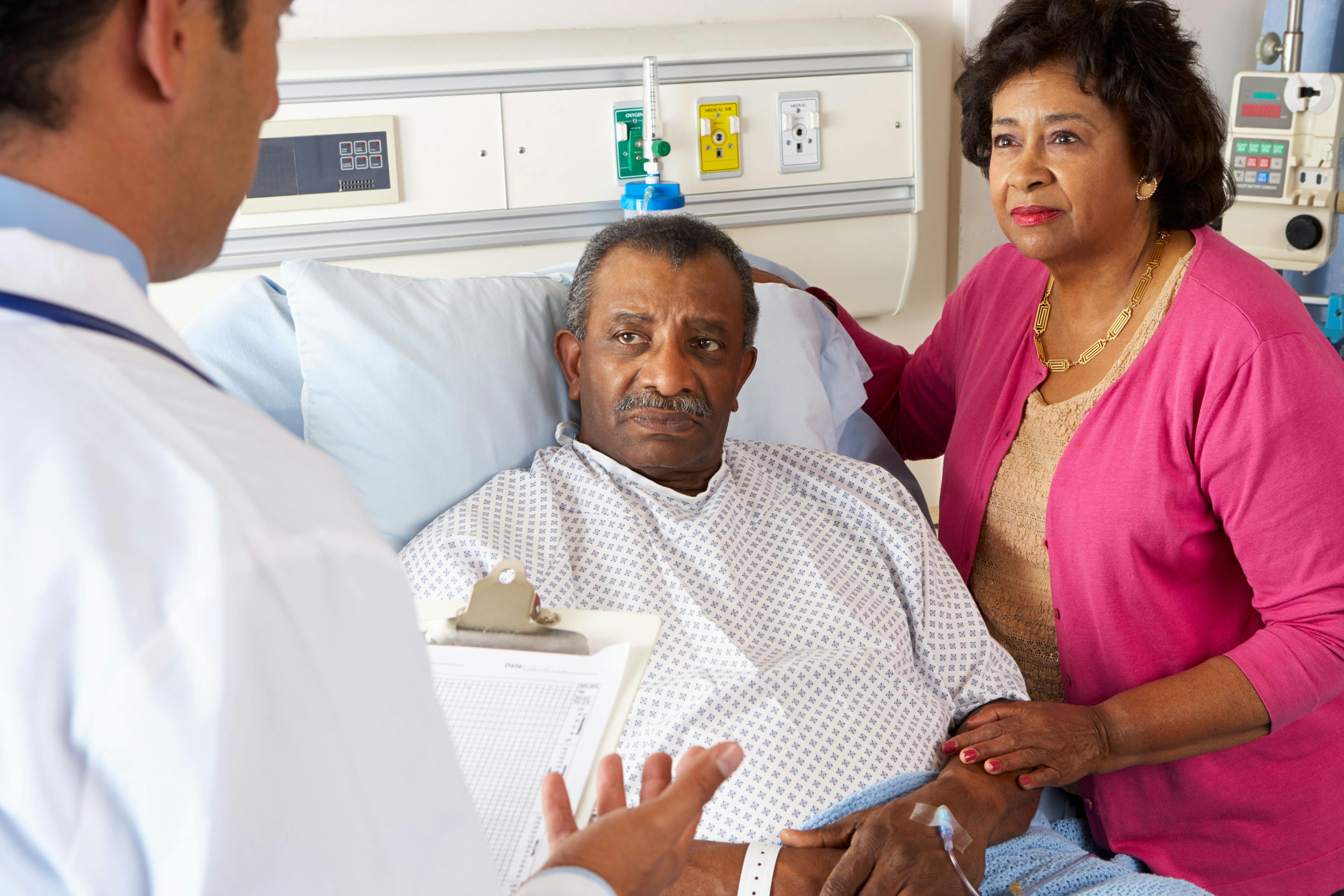 Older black patient speaking with a physician in the hospital.