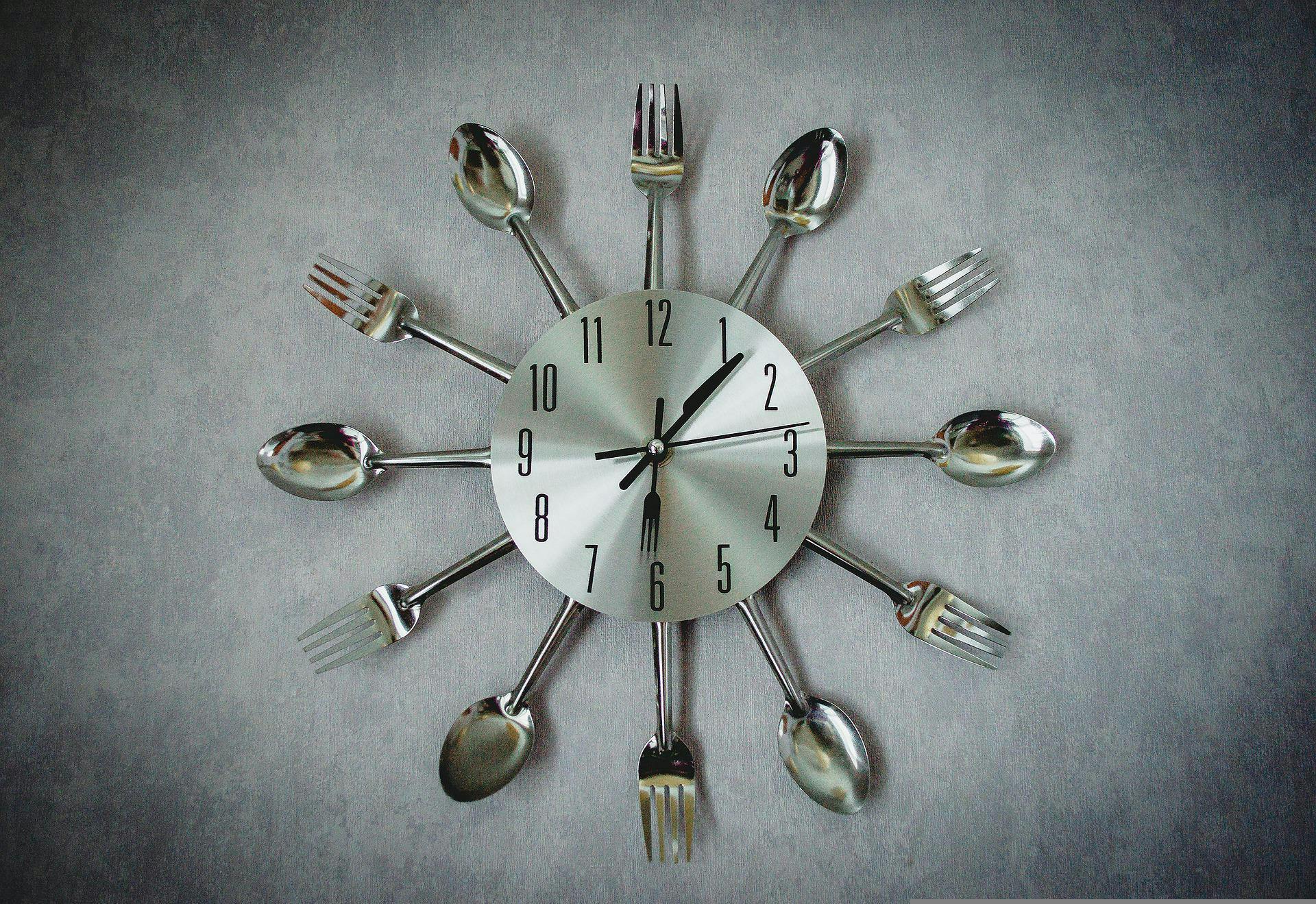 Clock surrounded by utensils.
