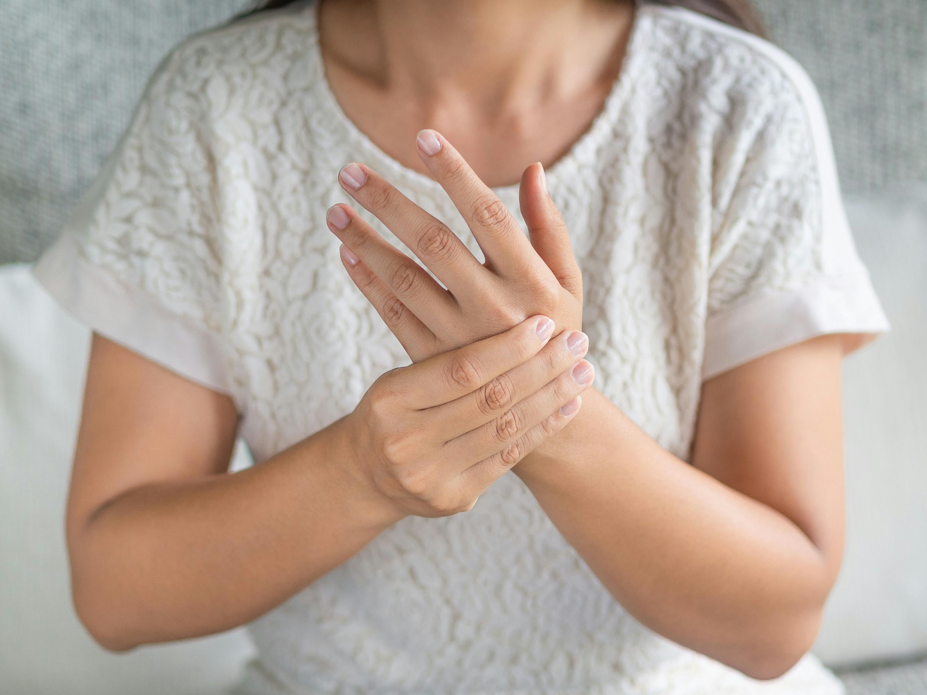 Woman experiencing statin-associated muscle symptoms in her hand