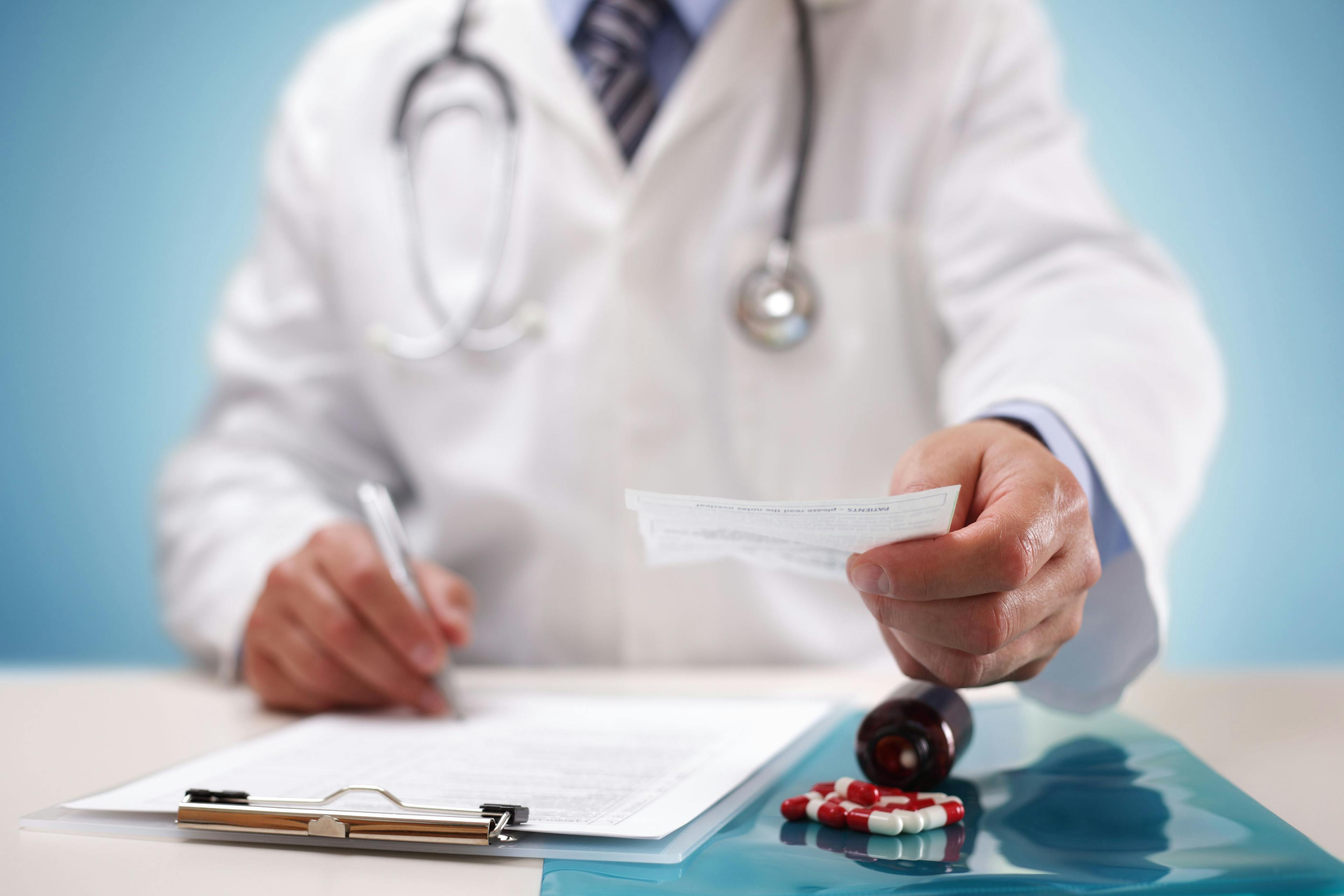 Healthcare provider handing over a prescription to a patient