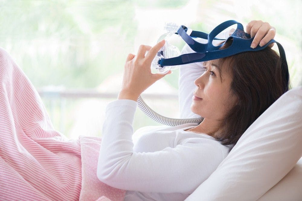 Woman using a sleep apnea machine.