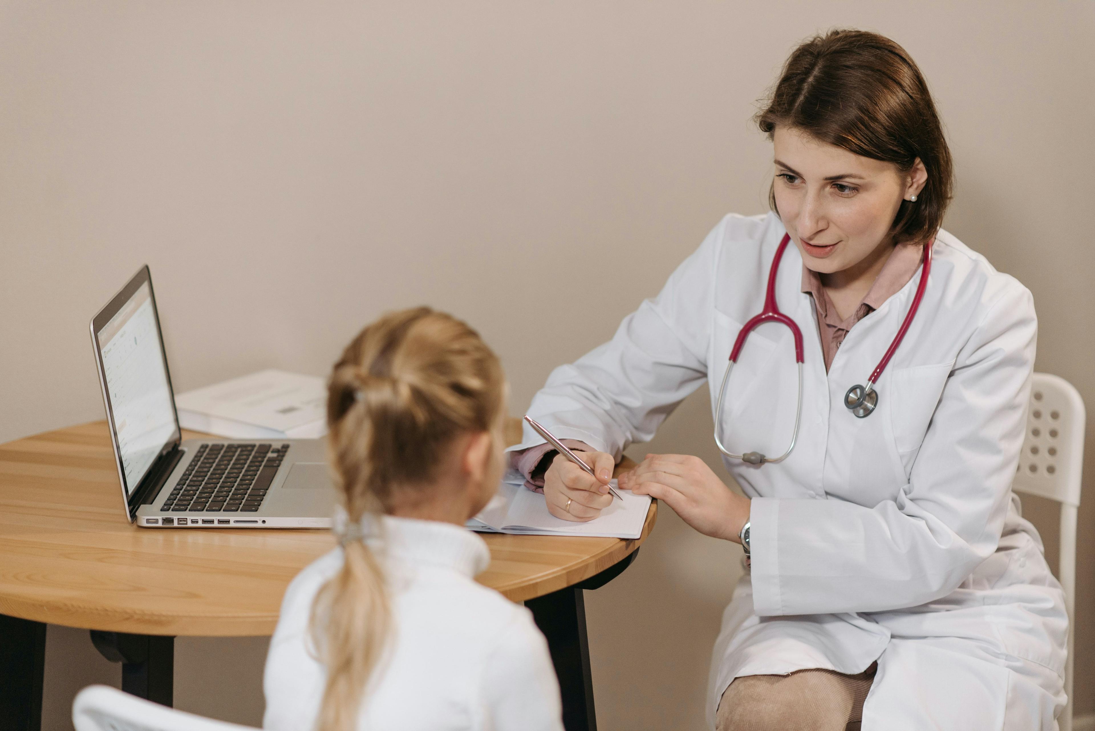 A pediatrician having a discussion with a young girl.