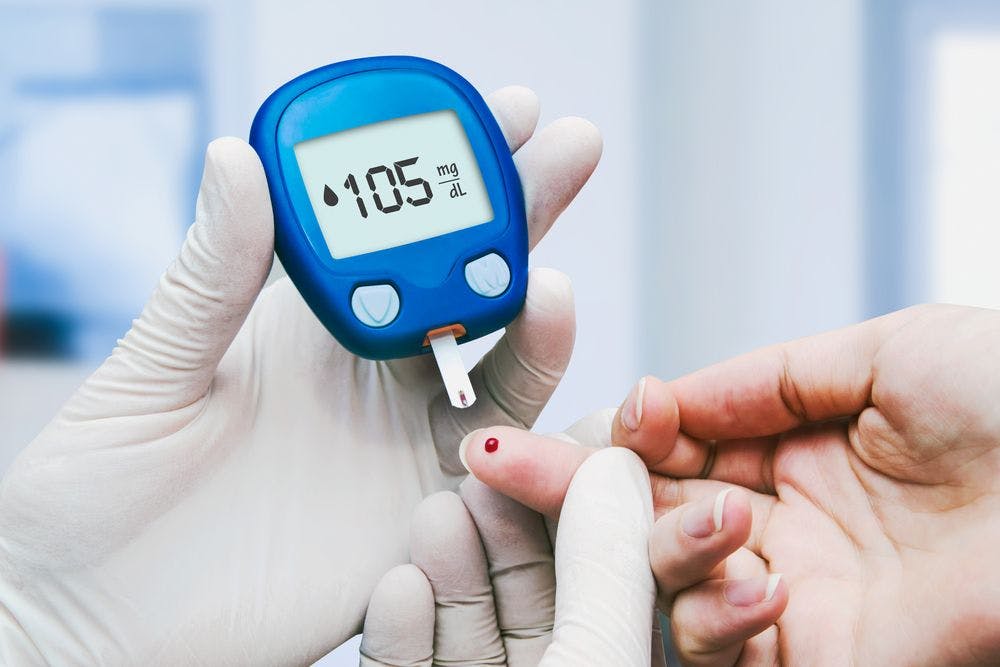 Stock image of a patient with diabetes checking their blood sugar levels with the help of a health care provider.