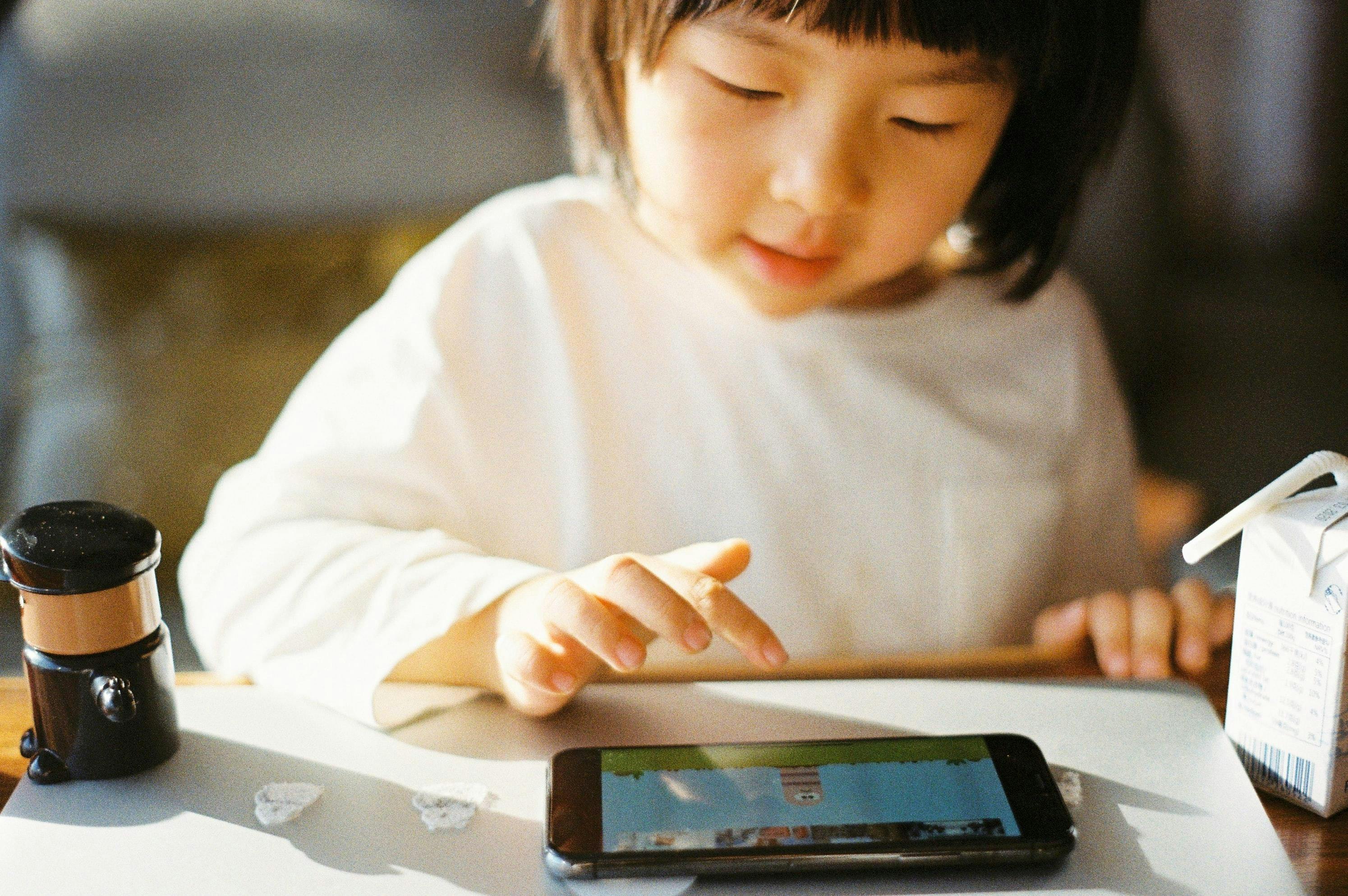 Young girl playing games on a smart phone.