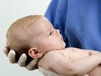 Doctor holding infant | Credit: Sanity