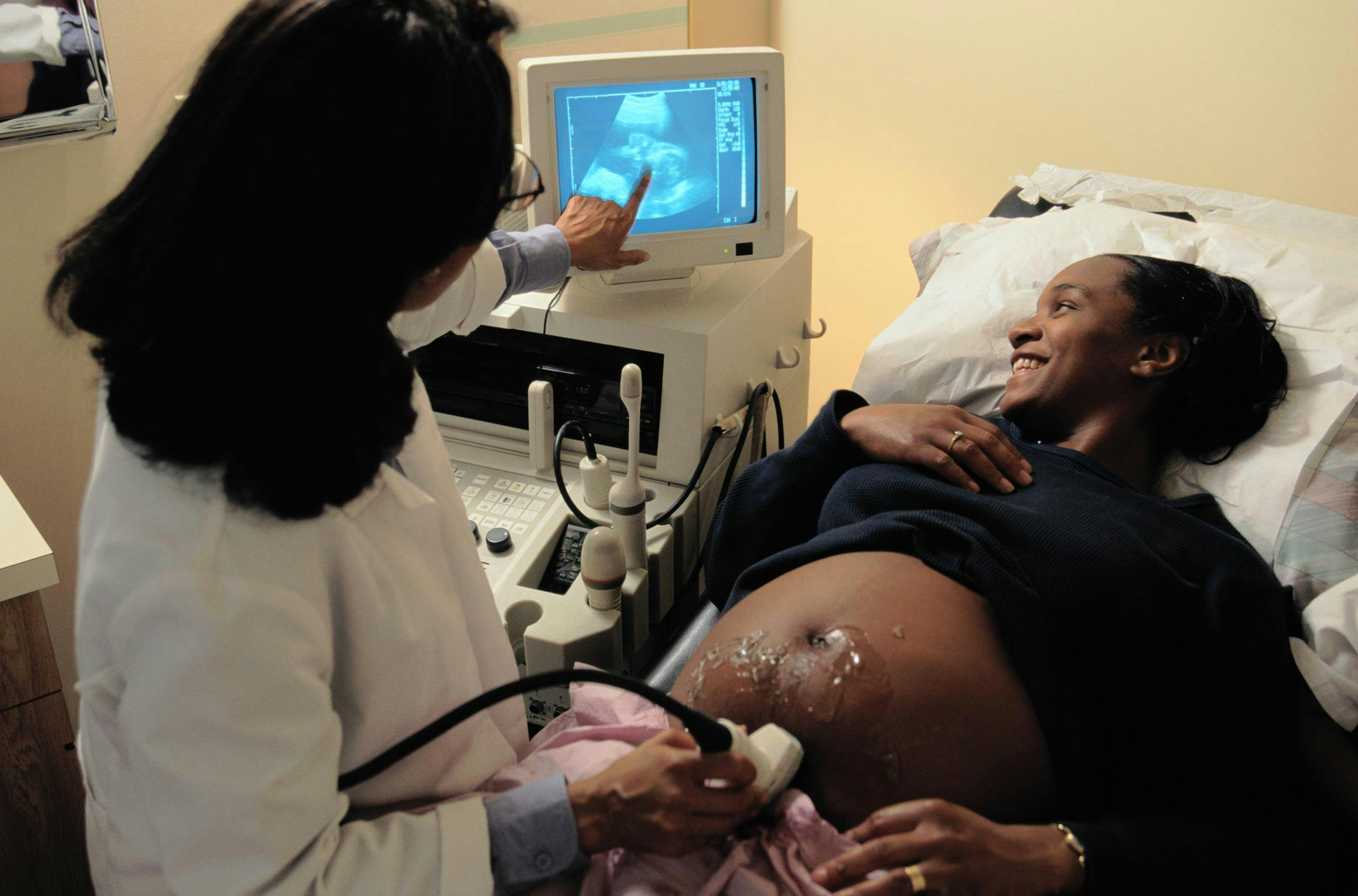 A pregnant Black woman undergoing an ultrasound