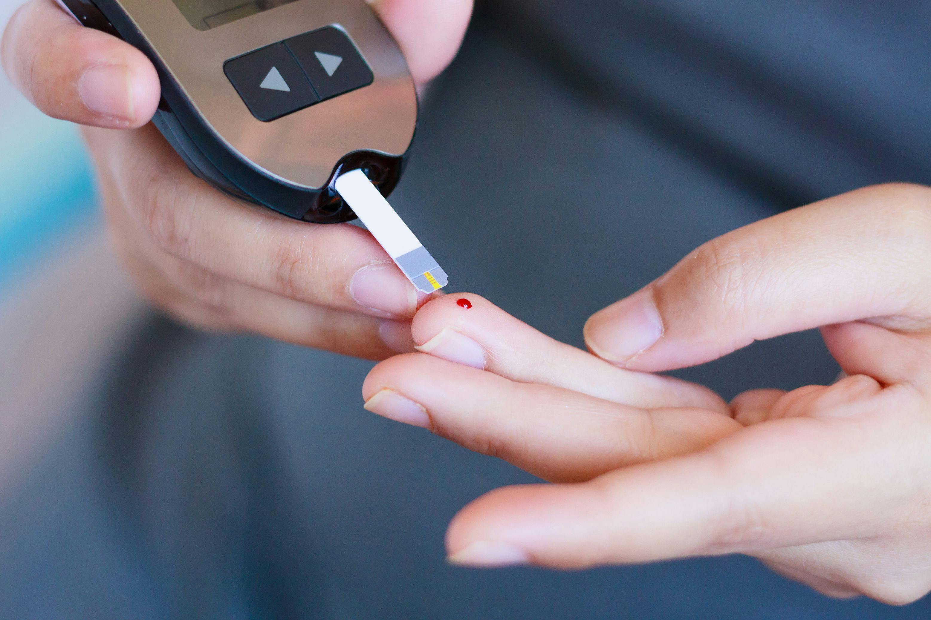 Patient checking their blood sugar from a finger prick using a conventional glucose monitoring 