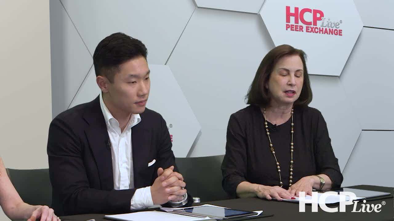 James Song, MD, and Adelaide Hebert, MD, sit at a table discussing seborrheic dermatitis. 