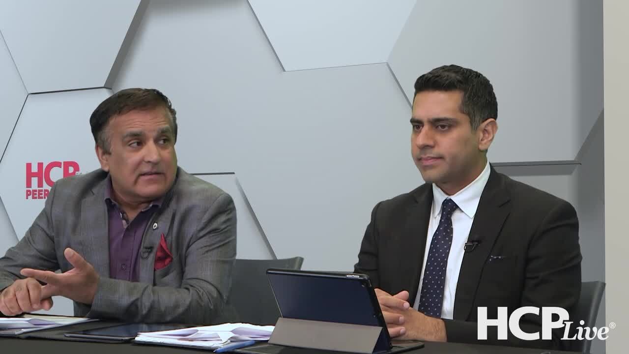 Neal Bhatia, MD, and Shawn Kwatra, MD, sit at a table discussing seborrheic dermatitis. 