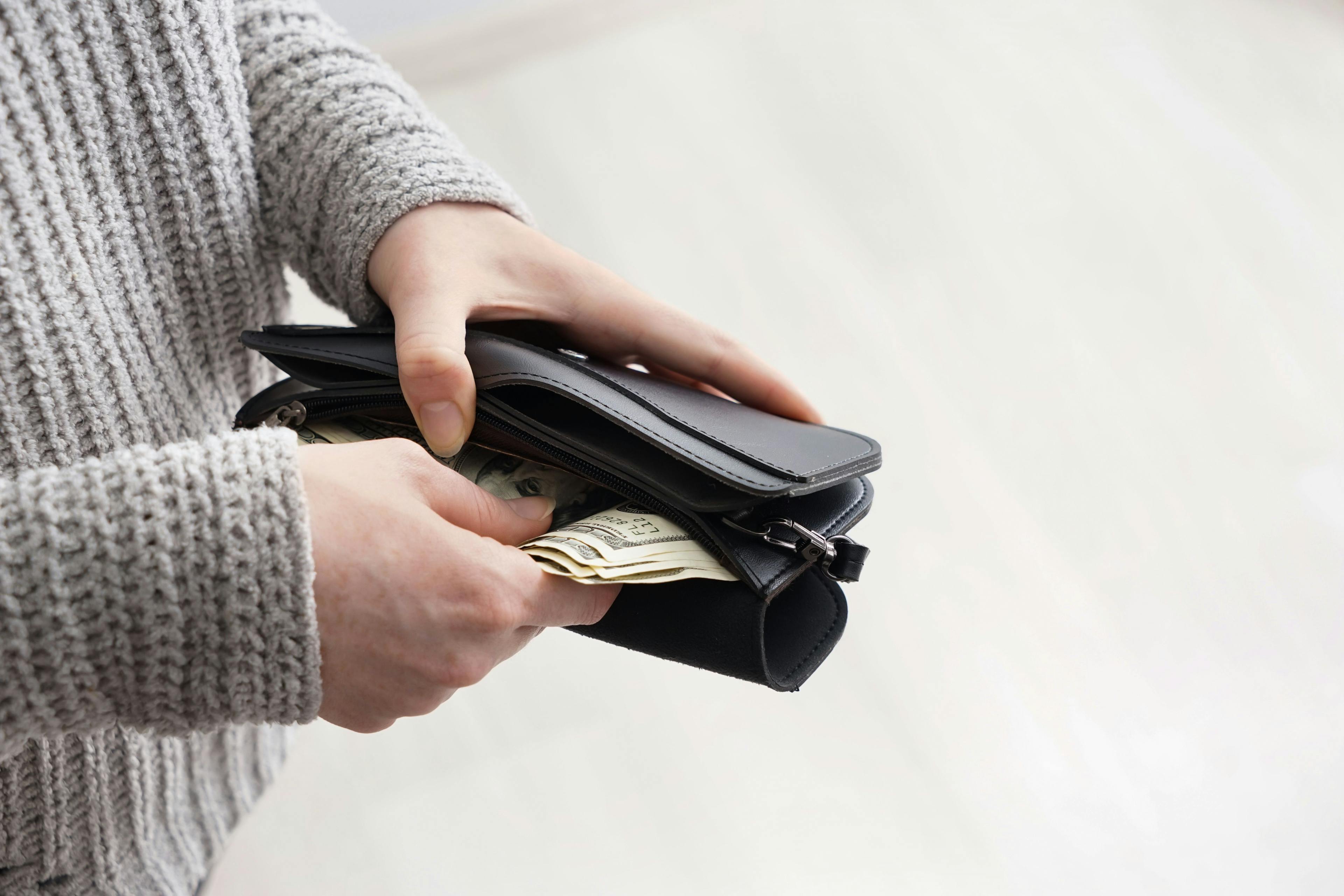 Person reaching into a wallet for money