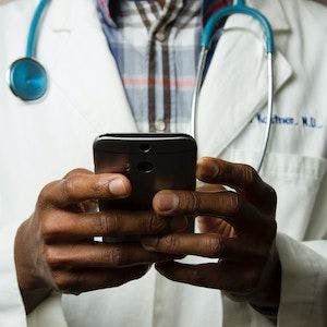Doctor holding a phone | Credit: National Cancer Institute/Unsplash