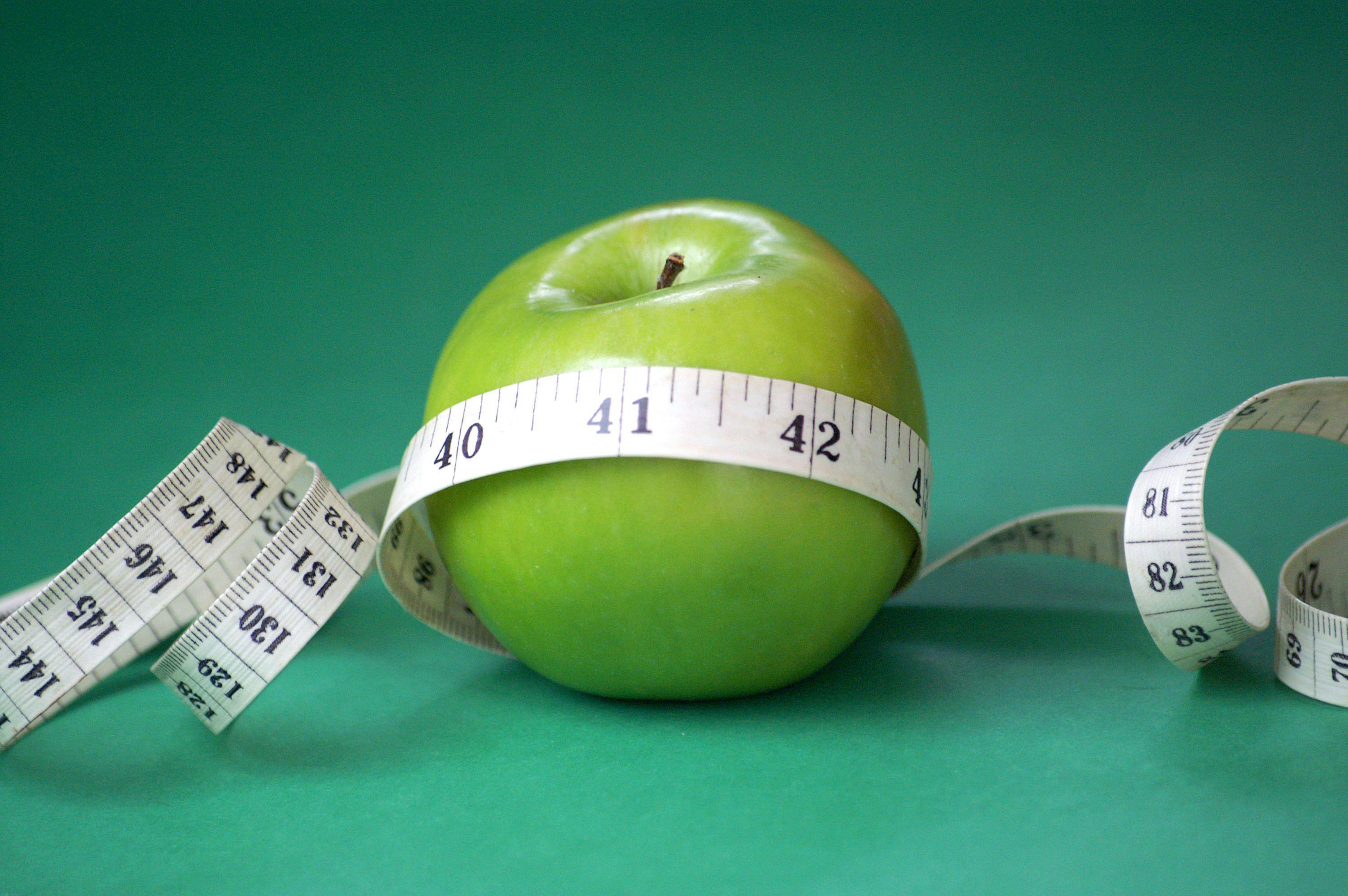 Apple enraptured in a measuring tape.